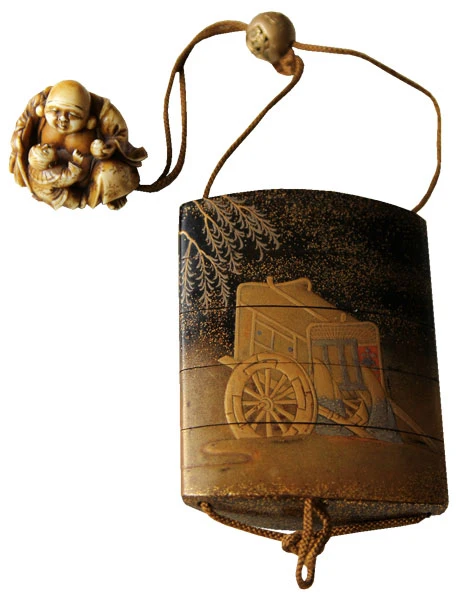 Eine kleines japanisches Holzkästchen mit einer Schnur und eine aus Elfenbein filigran geschnitzte runde Figur am Ende. Diese kleinen verzierten Kästchen, genannt Inro, wurden am Gürtel befestigt und durch die kleinen, Metapher darstellenden Figuren, genannt Netsuke, gehalten. Auf dem Kästchen ist eine Sänfte mit großen Rädern eingearbeitet.